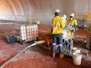 Grouting contracting team working with grout pumping equipment inside an industrial site. Title: Grouting contracting team onsite