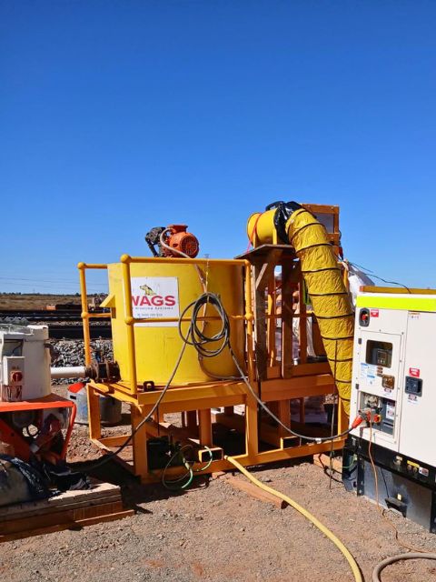 WAGS 1000 litre poly mixing system set up onsite beside a generator and grout equipment.